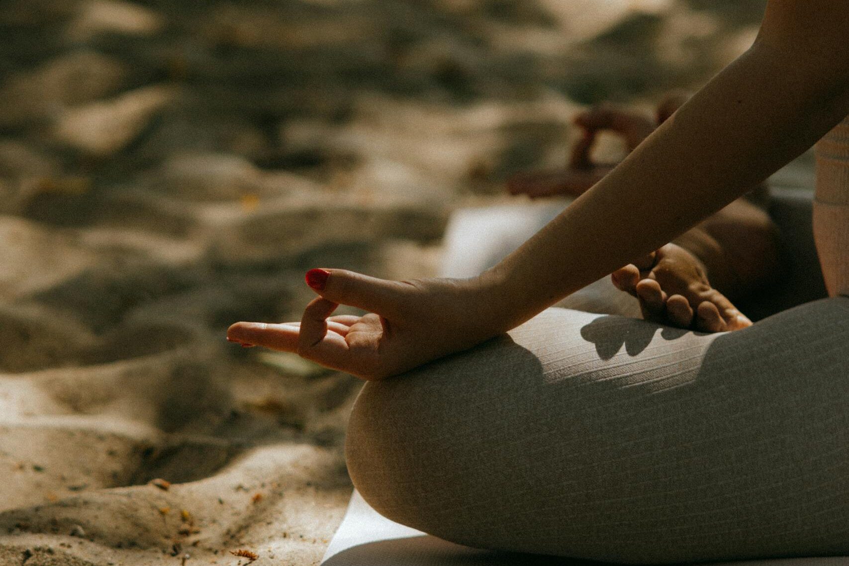 Close-up Shot of a Person Sitting on a Yoga Mat while Meditating