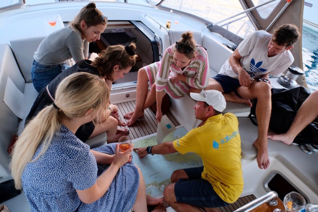 sailwithus Crew studiert gemeinsam Seekarte im Cockpit – Törnplanung mitsegeln