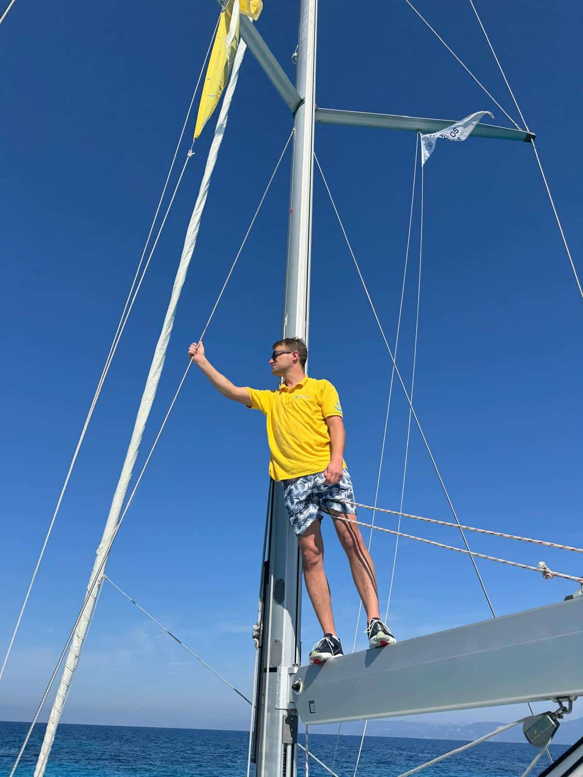 A sailwithus skipper in weather gear checking conditions on deck