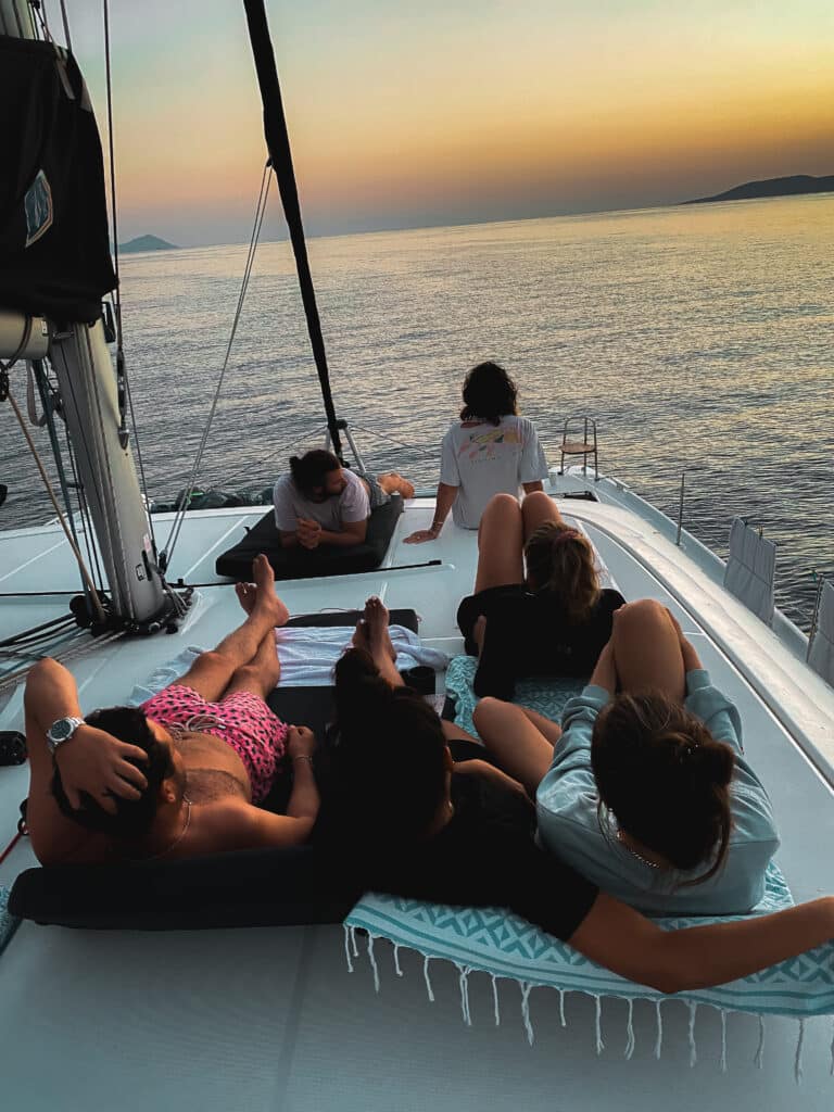 A family enjoying the sunset together on a sailing catamaran