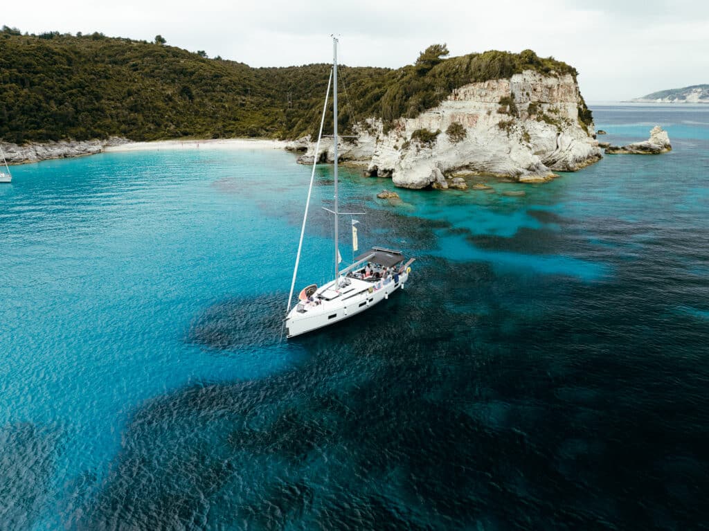 A sheltered Ionian bay with a sailing yacht anchored in calm water