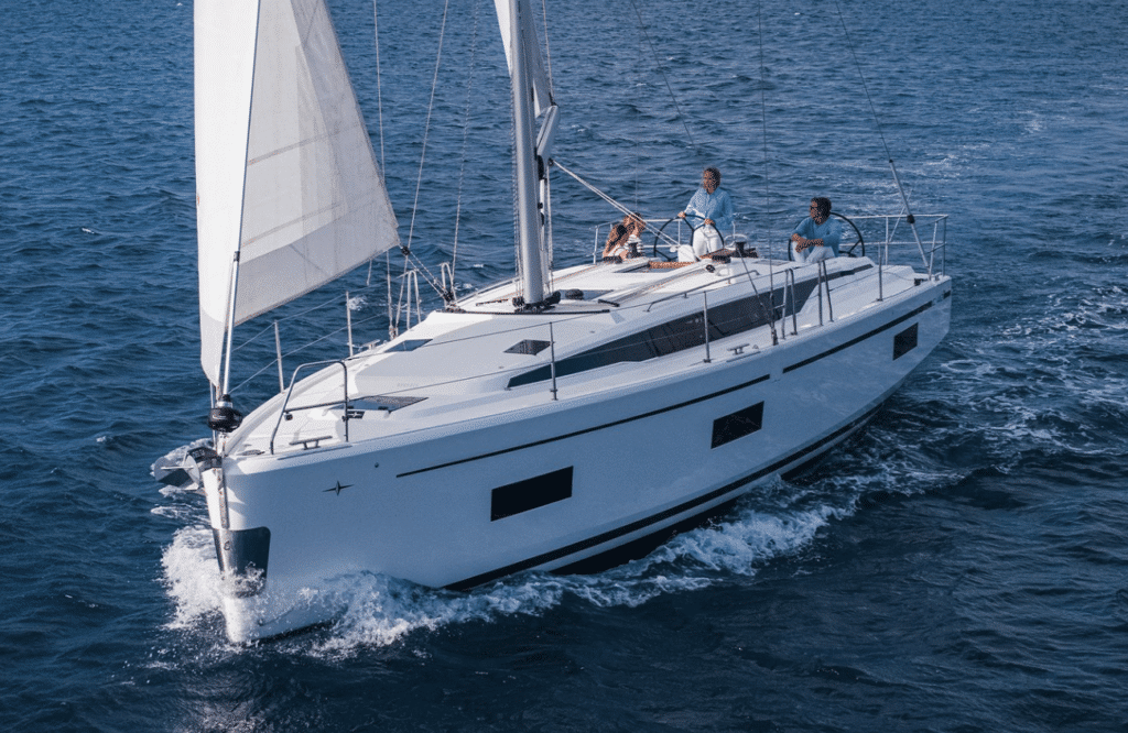 Segelyacht unter vollen Segeln auf offener See – Hand gegen Koje bedeutet aktives Mitsegeln