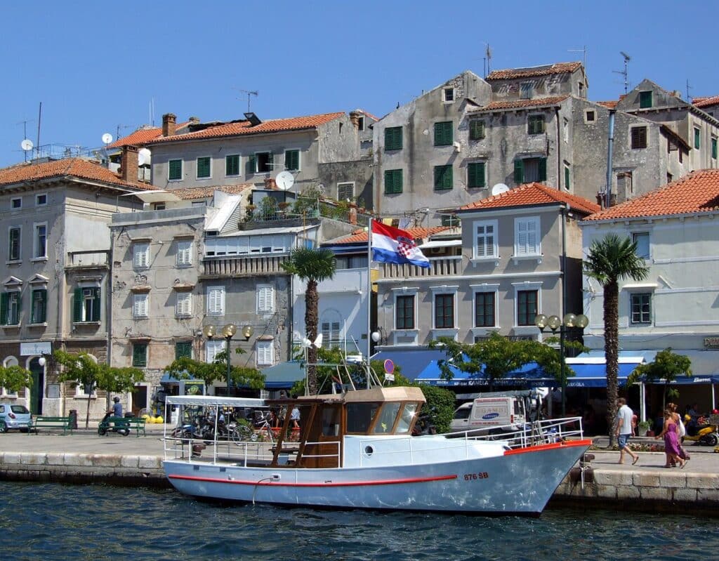 Hafenpromenade von Šibenik mit Fischerboot und Altstadt