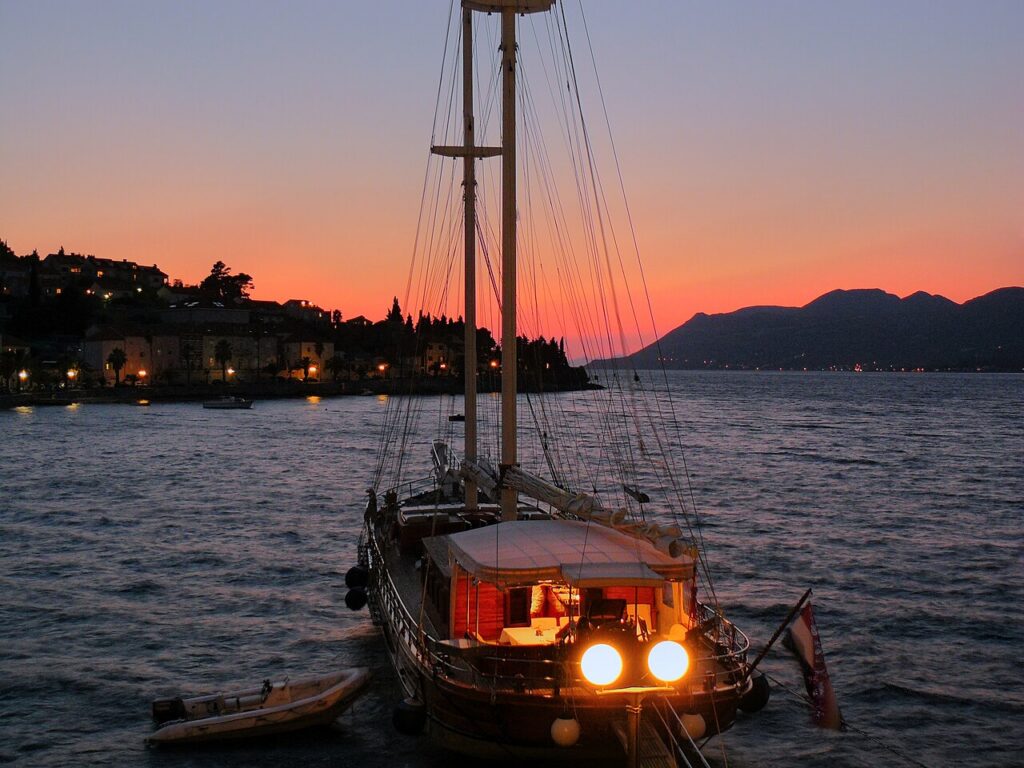 Traditionelles Segelschiff im Hafen von Korčula bei Sonnenuntergang