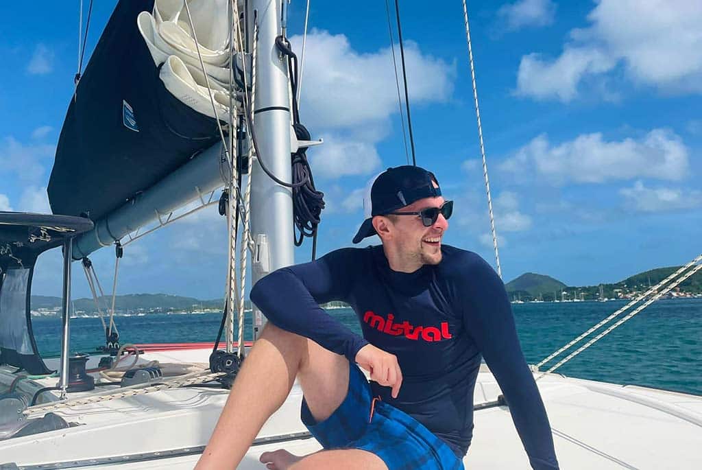 Lachender Mann auf Segelboot in der Karibik bei blauem Himmel – segelreise karibik sailwithus