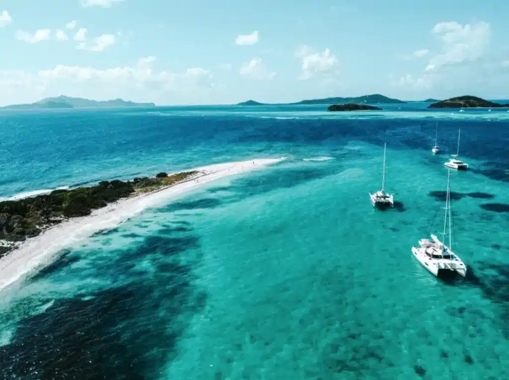 Katamarane ankern bei weißer Sandbank im türkisen Karibikwasser aus der Luft – segelreise karibik sailwithus